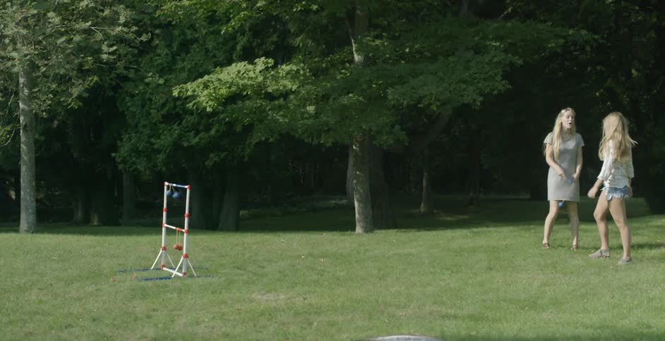 Two women are playing a game on the lawn