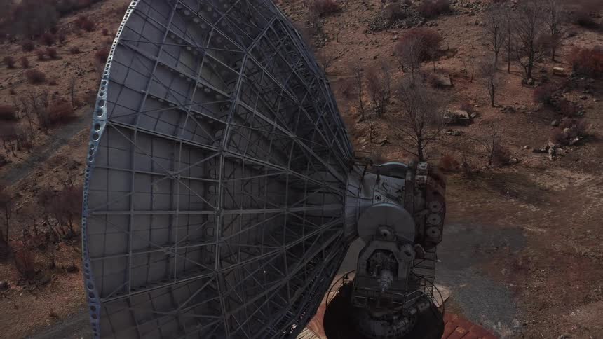 Aerial orbiting view of a big radio telescope on the countryside