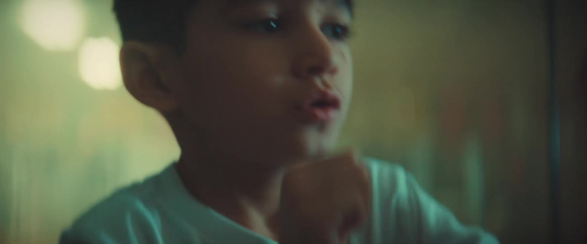 A boy shadow boxes indoors