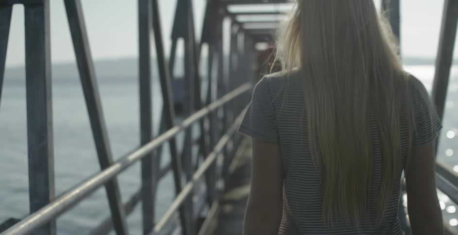 A woman walks across a bridge