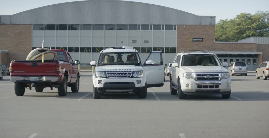 A woman gets into an suv with several other people