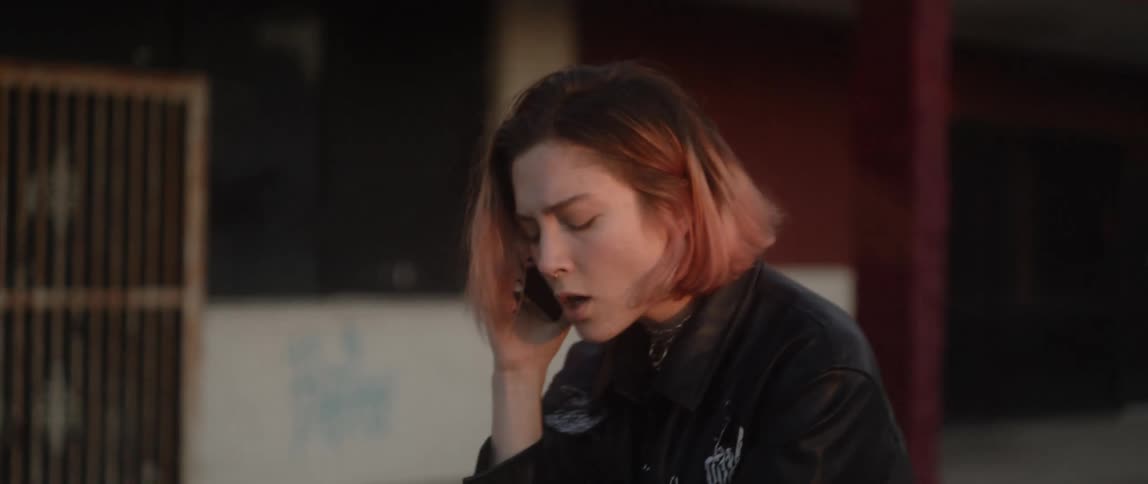 A young white woman is talking on the phone and is yelling at someone
