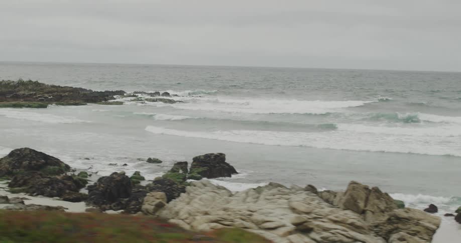 A beach littered with rocks and boulders on a cloudy day