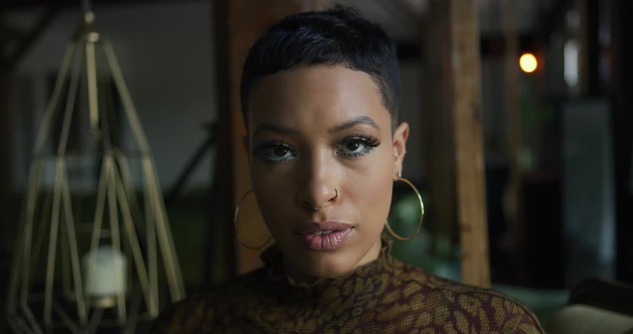 Woman wearing large hoop earrings and nose rings poses