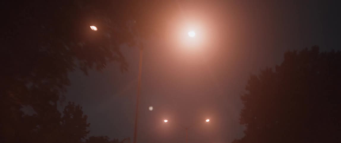 Car drives down road near the street lights at night