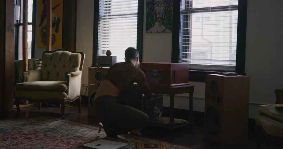 A woman is pulling records from the bottom shelf of a table