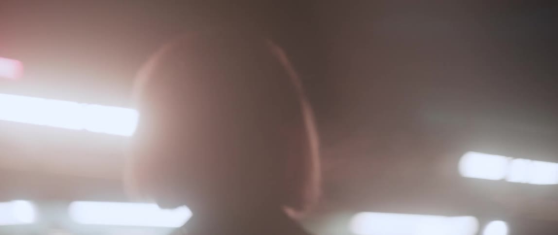 A young white woman is walking outside at night time into a night club