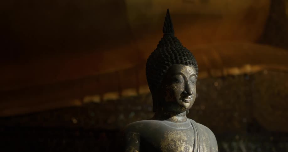 A bronze statue of buddha shows signs of aging on its surface