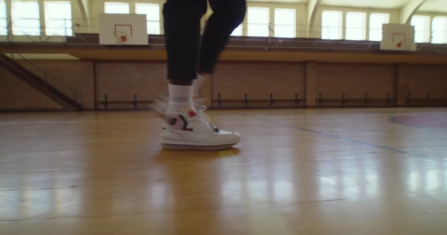 A person is playing basketball inside of a building