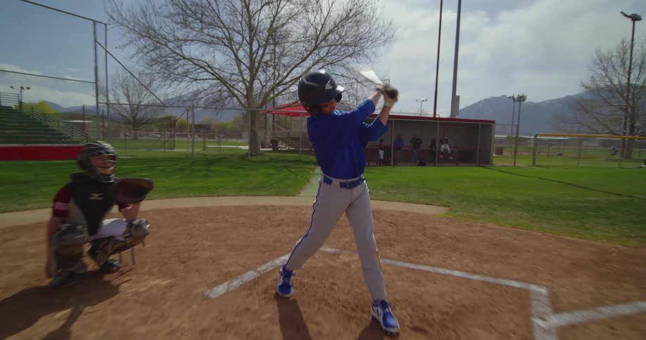 The child swings the bat at the ball