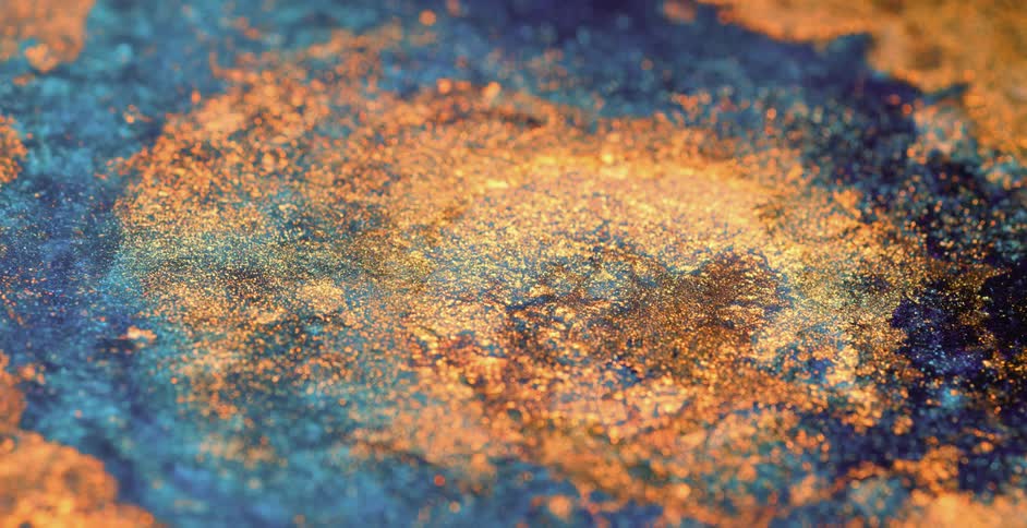 Gold glitter floating on liquid