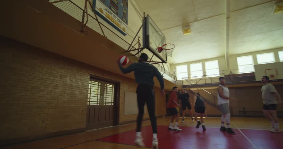 Basketball players pass the ball around and shoot
