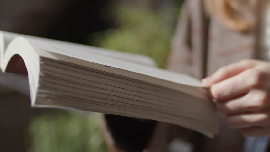 A woman is reading a book outside