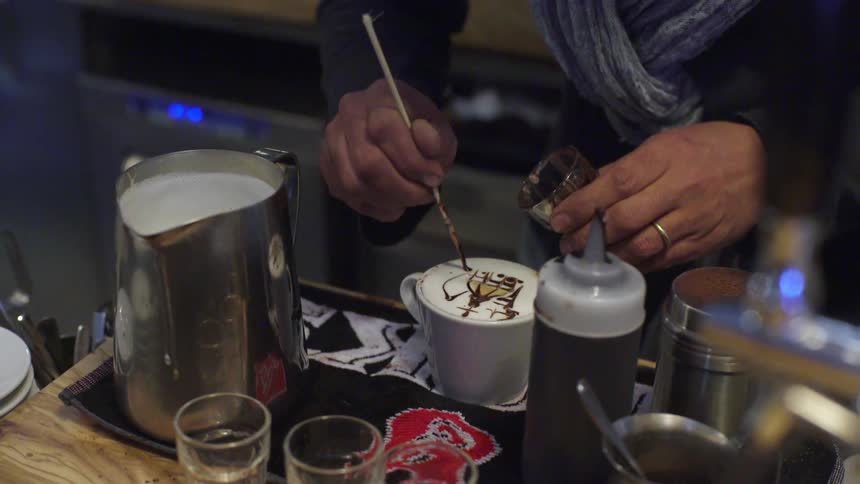 A person decorates a drink