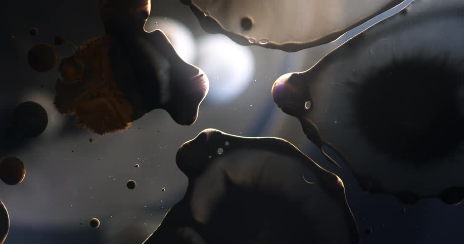 Close up of dark floating blobs of flowing liquid oily organic shapes growing and shrinking