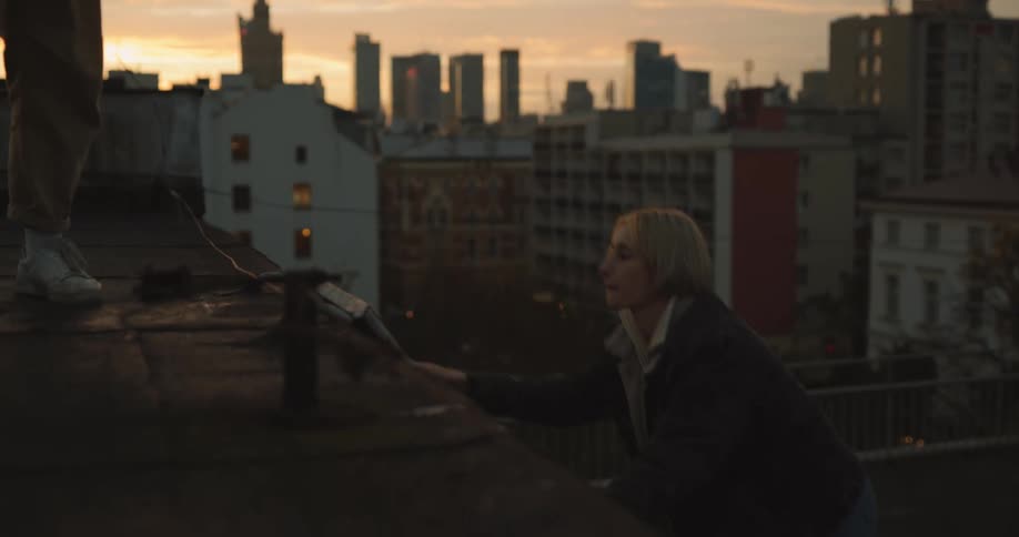 Two women climb the ladder to get to the roof