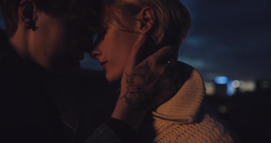 Man and woman sway together foreheads touching caressing each other under dark skies