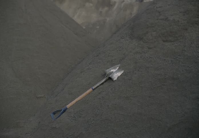 The shovel falls down the pile of dirt