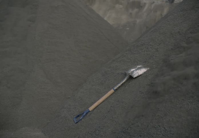A shovel lies in a pile of soil as the soil starts to slide downwards