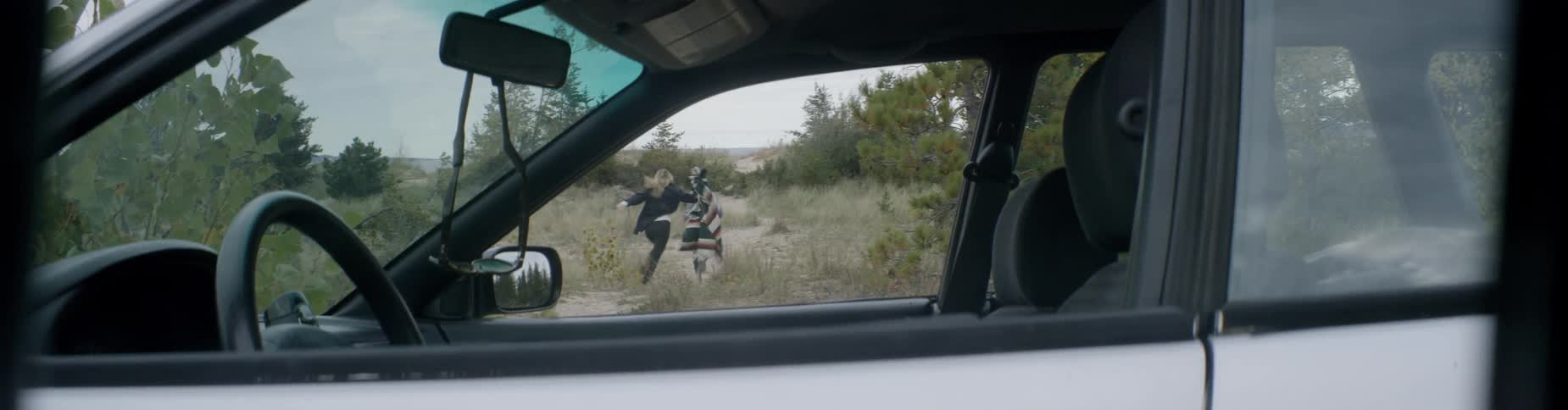 A man and woman run from a car down a trail ahead