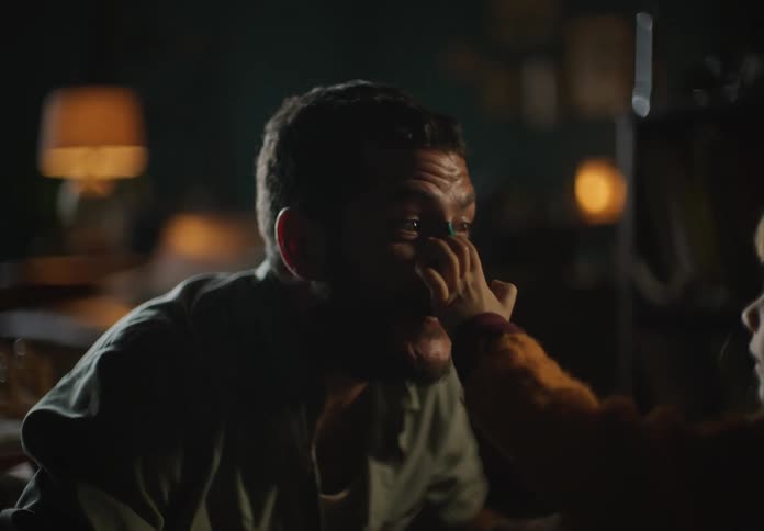 A man smiles wide as his daughter finger paints his nose