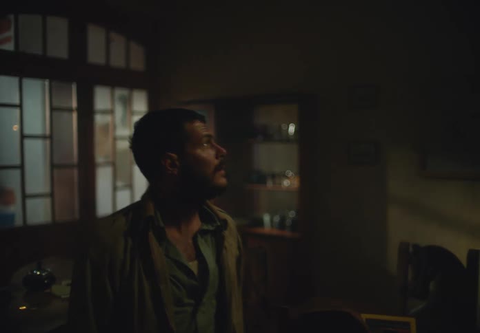 Man enters through doors and looks around dimlylit room