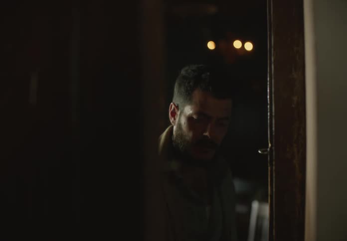 Man approaches door apprehensively before entering and crouching