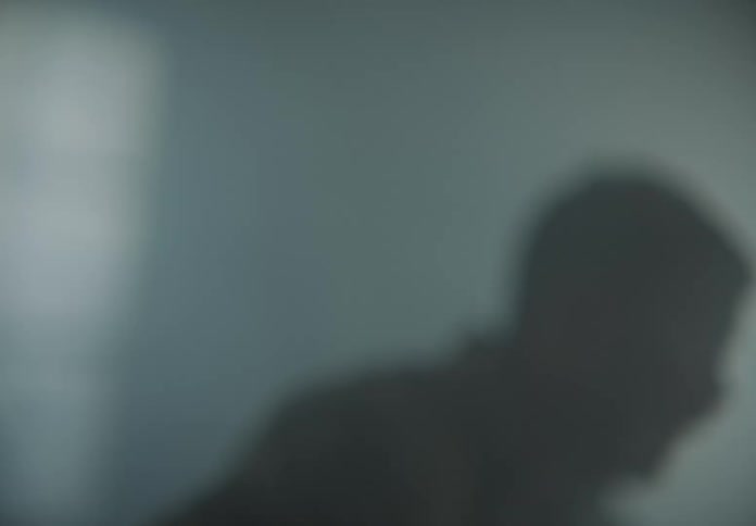 A man stands up in confusion in a smoke filled room