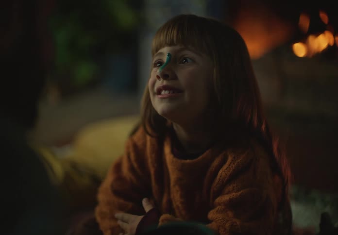 A child is talking by the fireplace