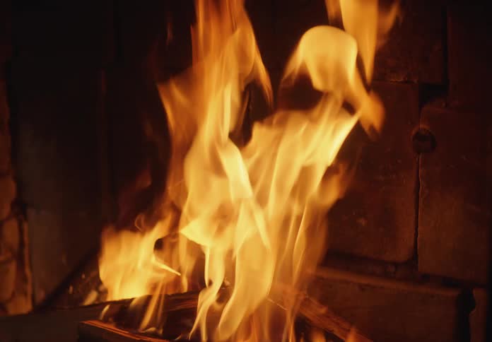 Close up of logs being consumed by fire inside the hearth of a fireplace