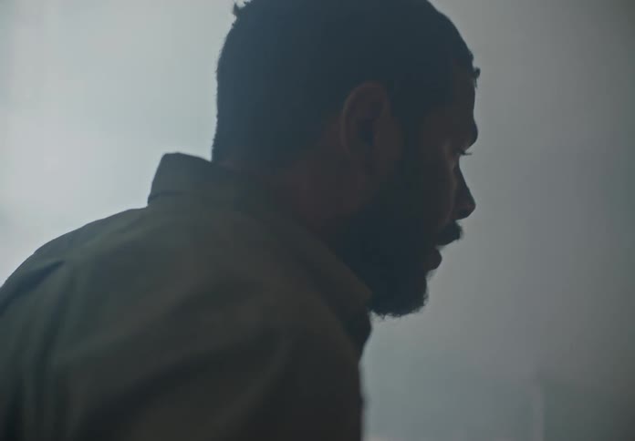 A man stumbling around in a smokey room