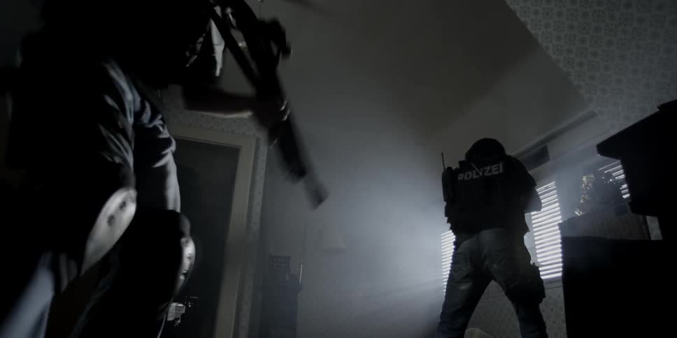 Police storm through a bedroom door with their weapons drawn