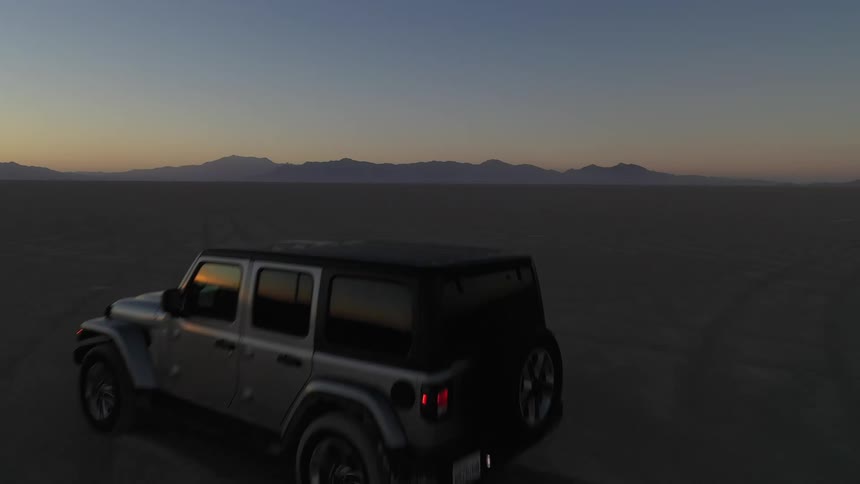 Jeep wrangler driving across the desert at dusk