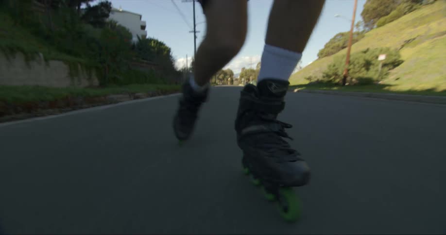 A person is rollerblading outside in the middle of the day
