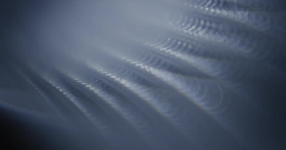 Light moves across a textured surface from right to left
