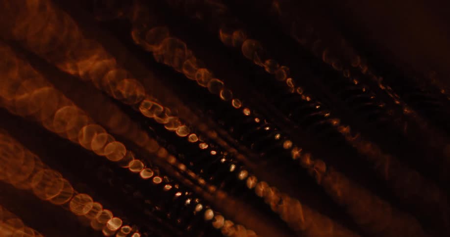 Metallic surface shimmers as light shines on its ribbed notched pattern