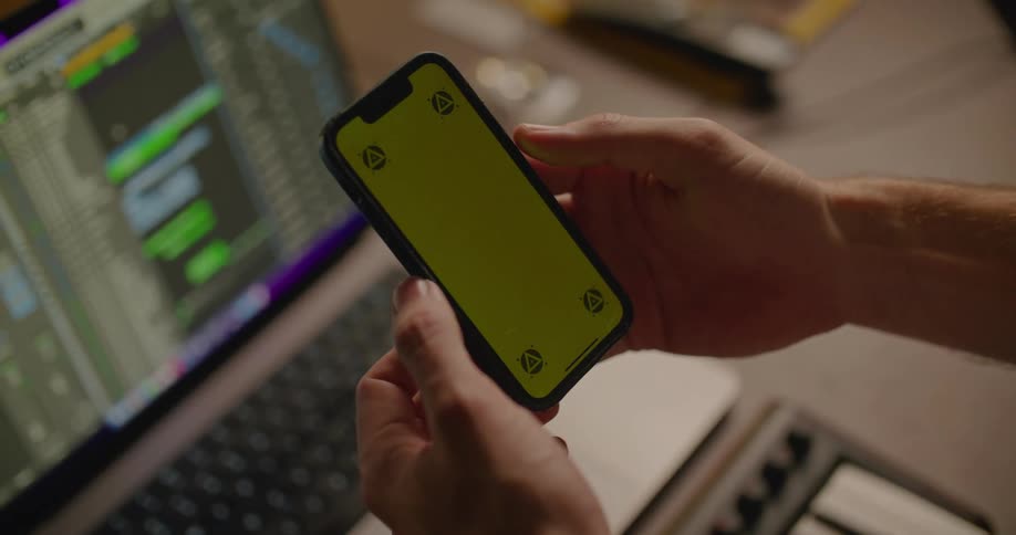 A person holding their smart phone swipes the screen with their thumb