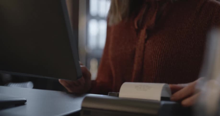 A woman is printing receipts on her computer