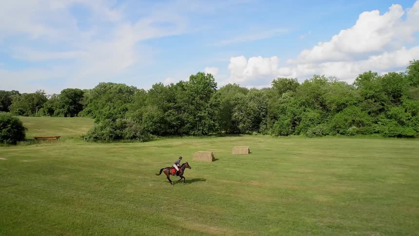 Someone riding a horse across a field