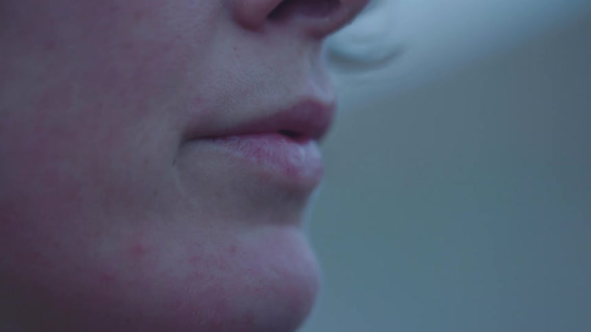 Close up of the lips of a woman standing outdoors at morning