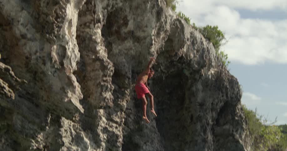 A child jumping off a cliff into the ocean