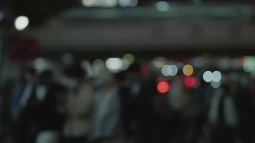 A group of pedestrians are walking during the night
