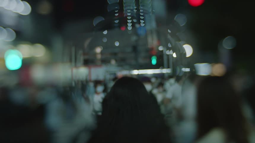 A crowd walks down a busy city sidewalk
