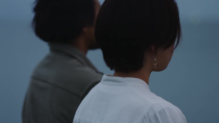 Two people are standing outdoors side by side