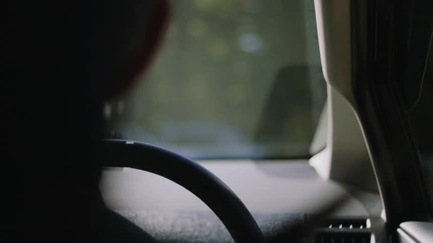 A man is driving a vehicle through a neighborhood