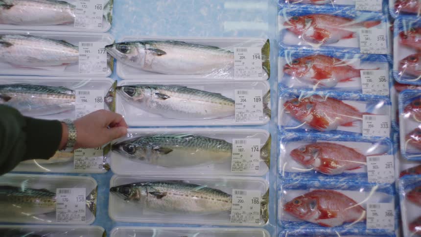 A customer picks up a fish from the market