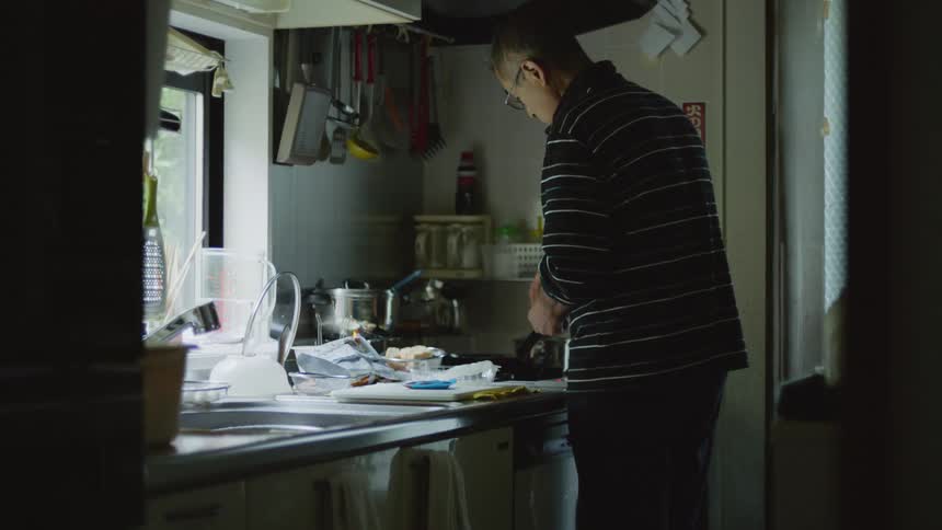 Man cooking a meal in a skillet on the stove