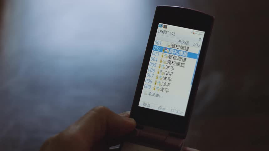 A man is holding a cell phone and the screen keeps changing
