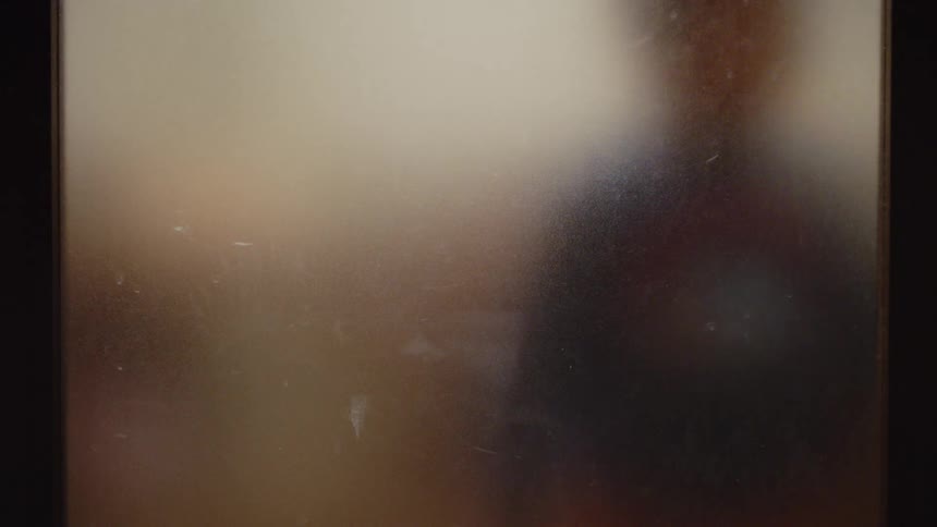 A child presses his face against the glass