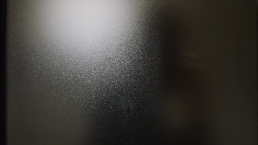 A persons silhouette sitting rolling on a chair